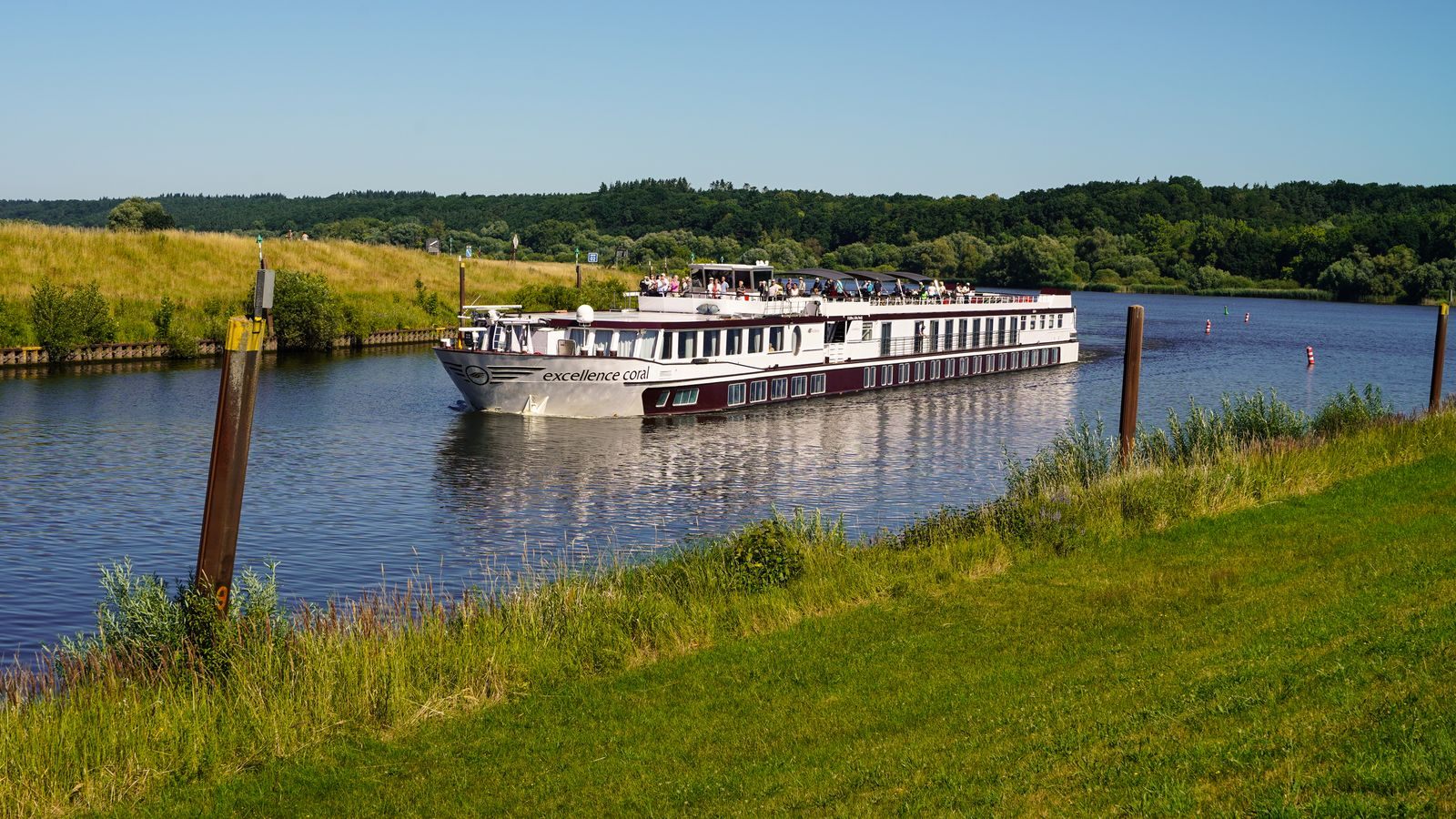 White river cruise ship moored along a green canal bank in Germany